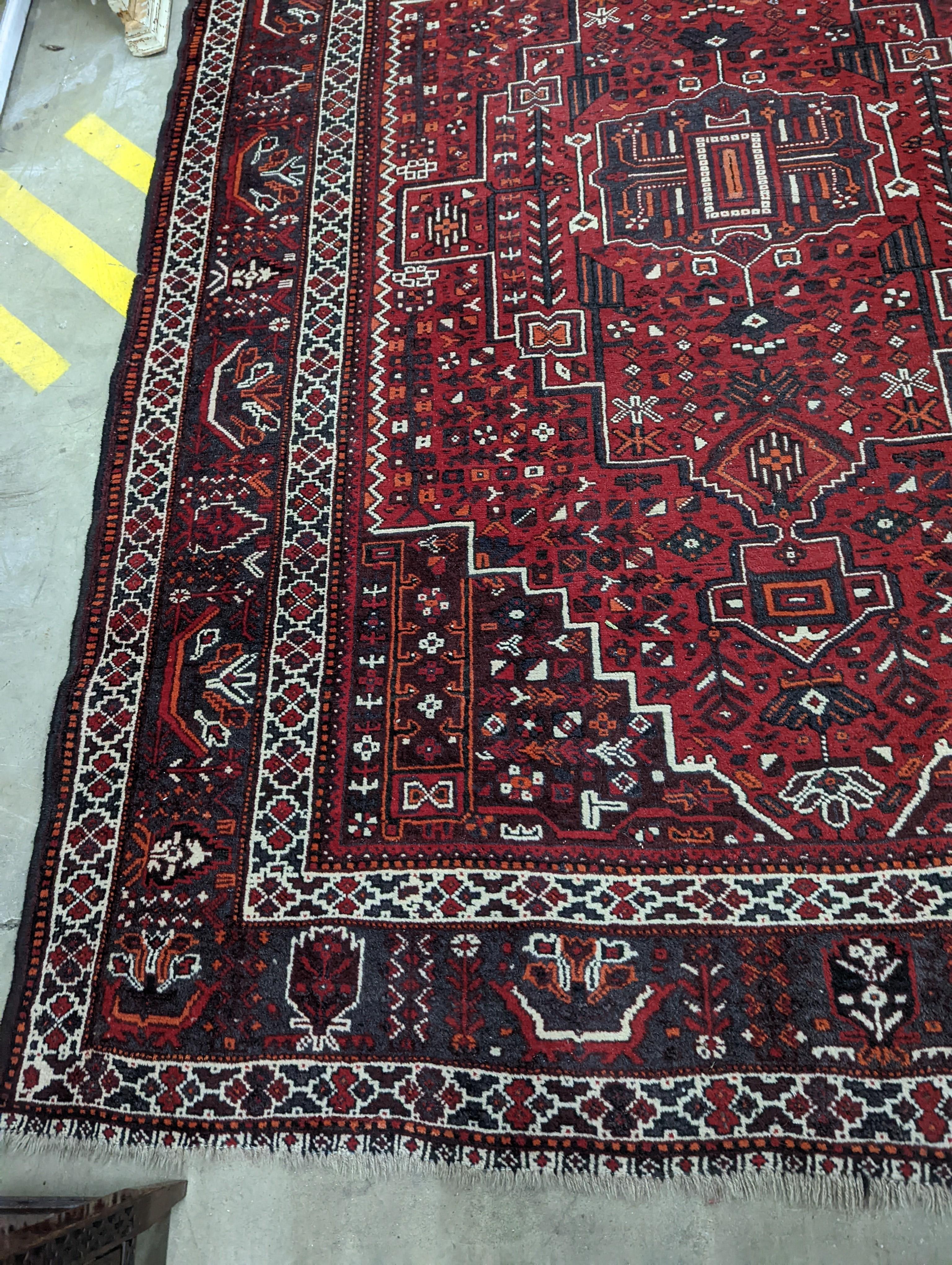 A Caucasian design burgundy ground carpet, 280 x 210cm